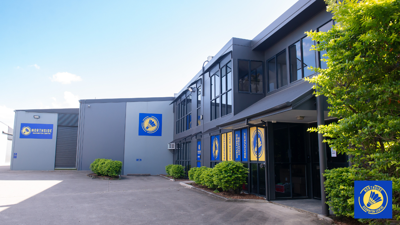 "Front view of Northside Badminton Centre showing the main entrance, modern sports facility building, signage, landscaped gardens, and parking area in Brendale, Queensland."